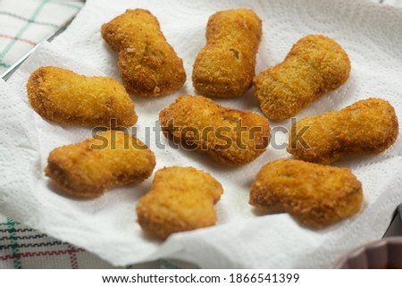 Stock photo of Fried crispy chicken nuggets with ketchup and cup of tea on white plate 