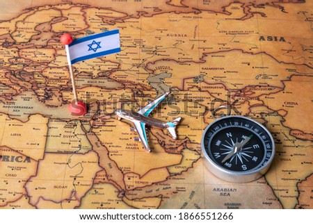 Flag of Israel, compass and plane on the world map. The concept of travel and tourism.
