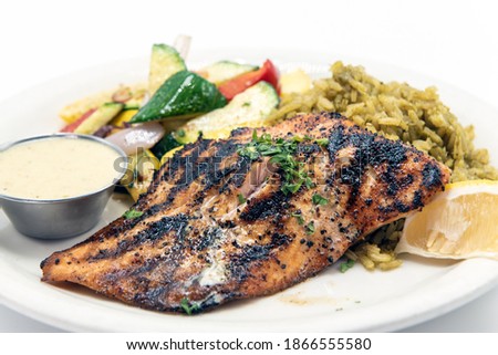 Large fillet of blackened salmon for a good source of protein on a plate of rice and fresh vegetables Royalty-Free Stock Photo #1866555580