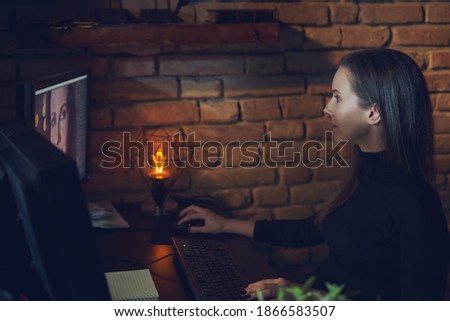 Woman editing photos on computer, retouching photos in studio.