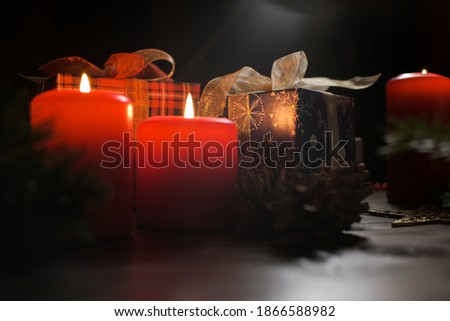 Christmas decoration with christmas bauble and candle for advent season four candles burning on black background