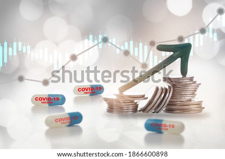 Economic recovery after covid-19 concept and purchasing coronavirus vaccine protection idea. Covid-19 drug capsule vaccine and green arrow upward on stack of coins on bokeh background