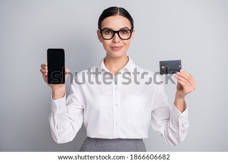 Photo of lady hold phone screen empty space show credit card wear specs white shirt isolated grey color background