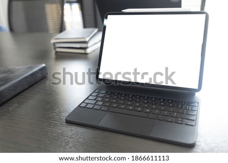 Cropped shot of trendy office desk with blank screen tablet, office supplies and decorations on white desk
