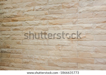 Wall lined with limestone slabs beige. Concept natural mineral background for the design.
