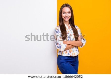 Photo portrait of woman with folded arms leaning against wall with blank space isolated on vivid yellow colored background