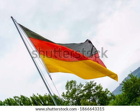 German flag waving over cloudy sky. High quality photo
