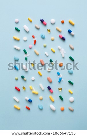 Creative layout of colorful pills and capsules on blue background. Minimal medical concept. Pharmaceutical, Covid-19 or Coronavirus. Flat lay, top view Royalty-Free Stock Photo #1866649135