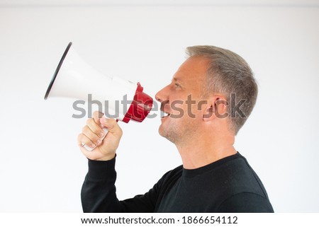 Young man talking in the megaphone on white background
