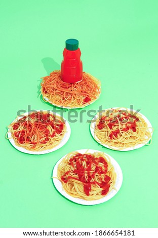 Spaghetti pasta with ketchup on green background. Minimalism. Italian food art concept.