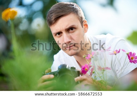 Serious male photographer naturalist takes pictures of nature
