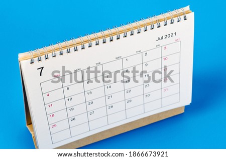 Close up July 2021 Calendar desk for organizer to plan and reminder on blue background.