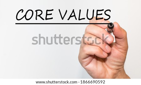 the hand writes text CORE VALUES with a marker on a white background. business concept