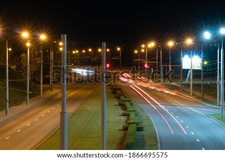 Night city light lines from cars. cars in highway with blur motion. Street view of the modern city at night. A lot of light from car headlights, advertising banners and night lights.