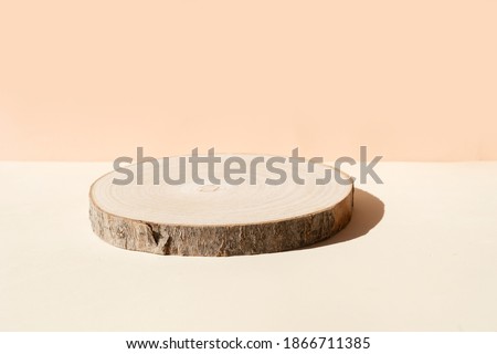 Minimal modern product display on textured beige background with wooden podium