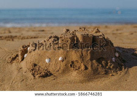 Closeup view photography of real cute big sand castle made by children on seashore