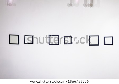 Blank photo frames on white wall in the exhibition room