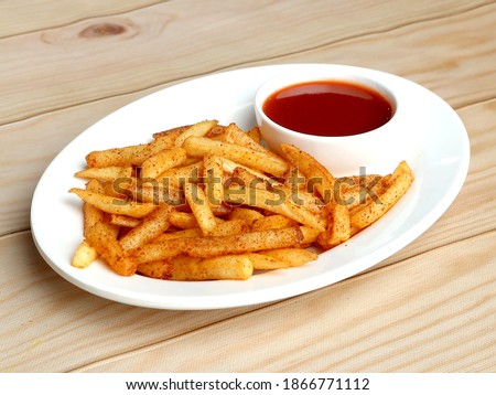 Tasty spicy Peri Peri French Fries with tomato ketchup served in a bowl over a rustic wooden background, selective focus Royalty-Free Stock Photo #1866771112