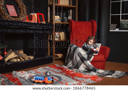 little girl sitting on a chair in a large room