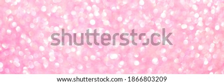 An abstract pink background with sparkle lights and bokeh. Useful as Christmas background or greeting card. Pink blurred light. Banner.