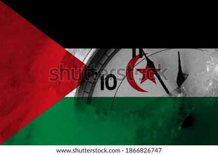 Sahrawi flag with clock close to midnight in the background. Happy New Year concept
