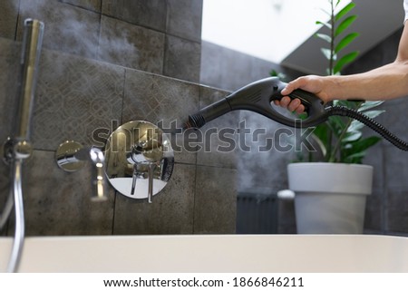 Cleaning and disinfection of the bathroom tap with steam. Professional cleaning process Royalty-Free Stock Photo #1866846211