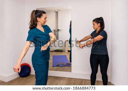 Stock photo of a woman doing rehabilitation exercises with professional worker.