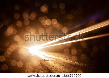 Horizontal night abstract picture with numerous of bokeh bright glow and track from the headlights of a fast-moving car