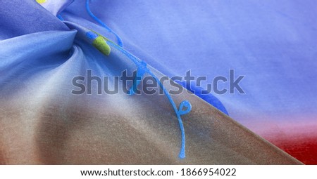 Background texture, silk fabric, shiny blue burgundy, with a small abstract print of rock paintings