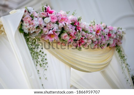 Arch for the wedding ceremony, decorated with cloth and flowers.