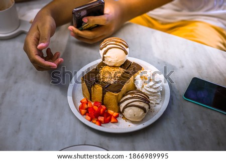 Blurred background view Of the dessert menu (Honey Toast) that contains ice cream, whipped cream, sour fruit like strawberries to be decorated and served to the customer.