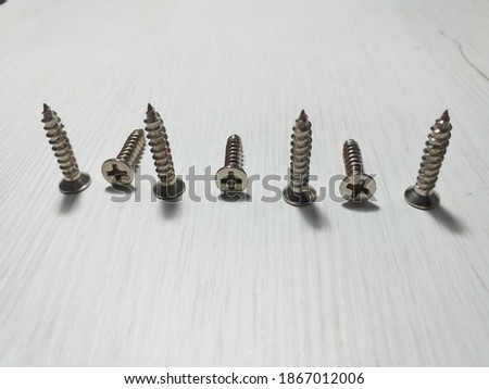 seven screw bolts on white wooden desk