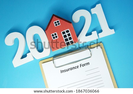 2021 and Home Insurance form  object on blue  background - House property insurance new year 2021 concept                                                               