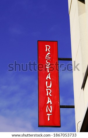 restaurant light red text sign on entrance building facade in street signboard