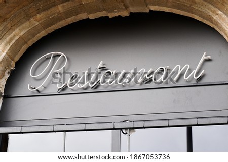 restaurant text sign front of french building entrance in city street
