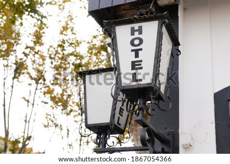 Hotel sign text write on old lamp vintage retro front of building in tourist city