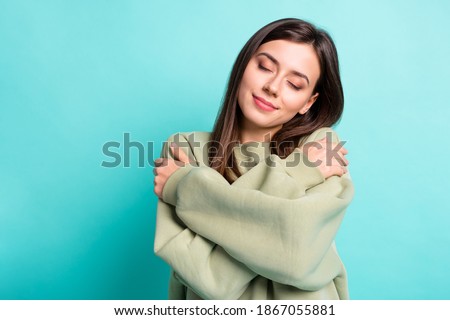 Photo portrait of calm woman hugging self isolated on vivid teal colored background Royalty-Free Stock Photo #1867055881