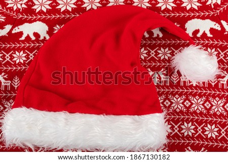Close up picture of Santa hat on red knitted pullover 
