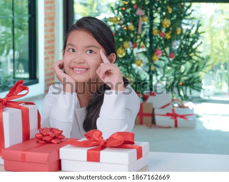 Happy cute girl with gift boxes at home with festive decorations. Merry Christmas, Happy New Year.