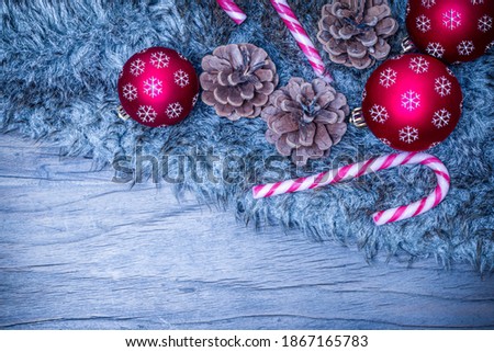 Christmas decoration on fur blanket on wooden background. Blue tone.