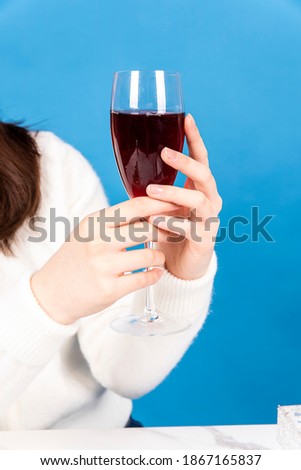 Close up picture of a woman's hand holding a glass of wine