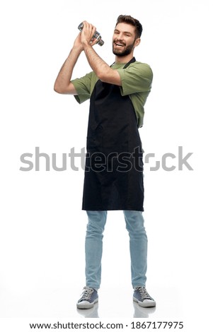 alcohol drinks, people and job concept - happy smiling barman in black apron with shaker preparing cocktail over white background Royalty-Free Stock Photo #1867177975