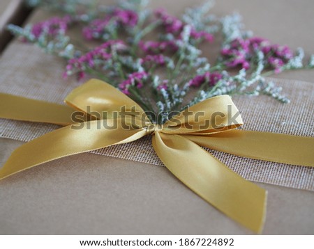 brown paper gift box tied with a golden ribbon and decorated with dried flowers, Festival Gifts for Christmas and Happy New Year