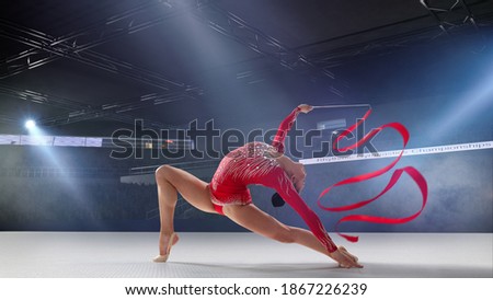 Rhythmic gymnast in professional arena. Royalty-Free Stock Photo #1867226239