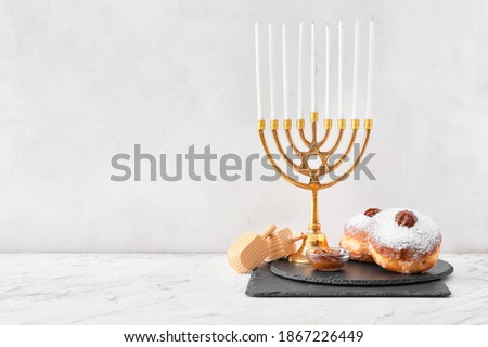 Menorah, dreidels and donuts for Hanukkah on white background