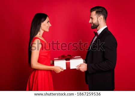 Profile photo of nice optimistic couple give present wear suit dress isolated on red color background