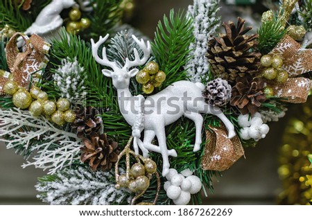 Christmas tree with a white deer, Christmas tinsel on the background of a fir tree, close-up decoration