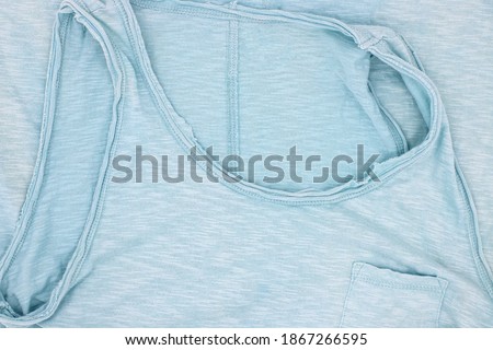 Faded green t-shirt folded top view photo. Grunge fashion style clothing. Folded woman top flat lay. Worn and faded textile of used female shirt. Basic wardrobe item. Retail industry banner template
