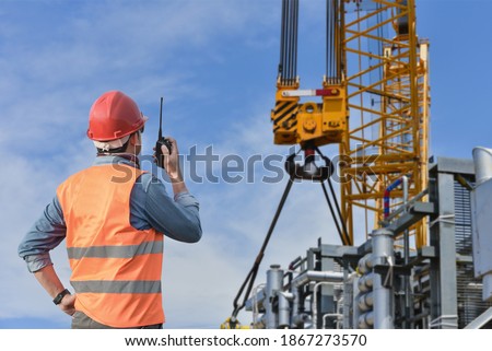 foreman, supervisor, worker, loading master in works at job site, control to the teamwork by walkie talkie radio for job done in the same direction, working at risk and high level of insurance Royalty-Free Stock Photo #1867273570