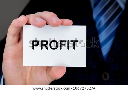 Close-up of man's hand holding and showing visiting card with PROFIT word on it.